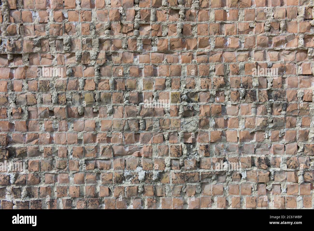 Immagine di un vecchio muro di pietra grungo in mattoni fatto con pietre quadrate cotte al forno Foto Stock