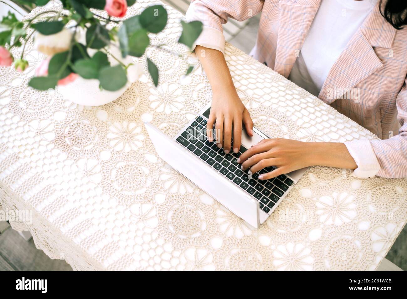 Donna seduta al tavolo e che lavora al computer portatile. Foto Stock