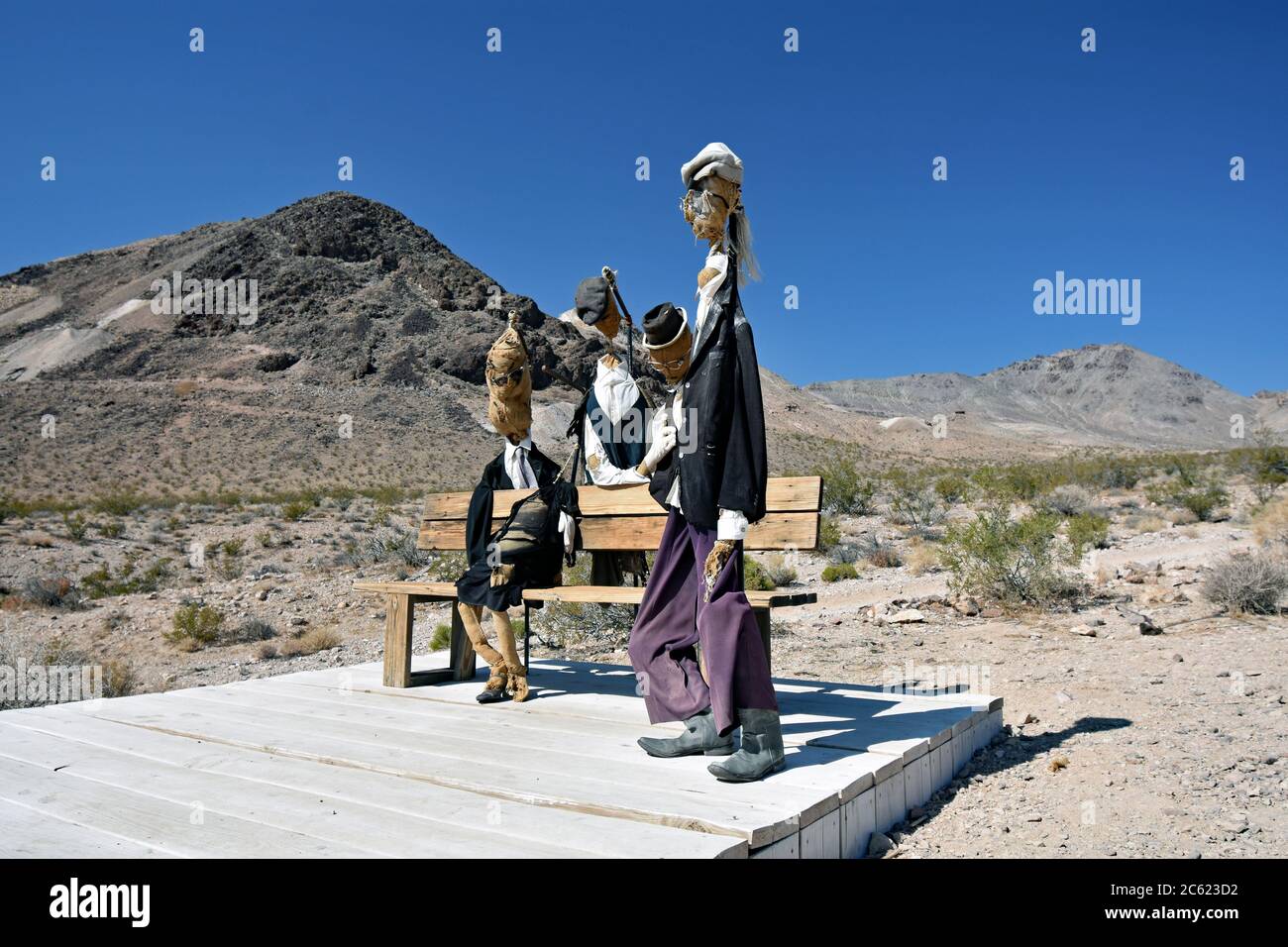 Quattro sculture di burlap ripiene di persone intorno a una panchina nel deserto. Intemperie danneggiate e sole sbiancato. Museo all'aperto GOLDWELL, Nevada Foto Stock