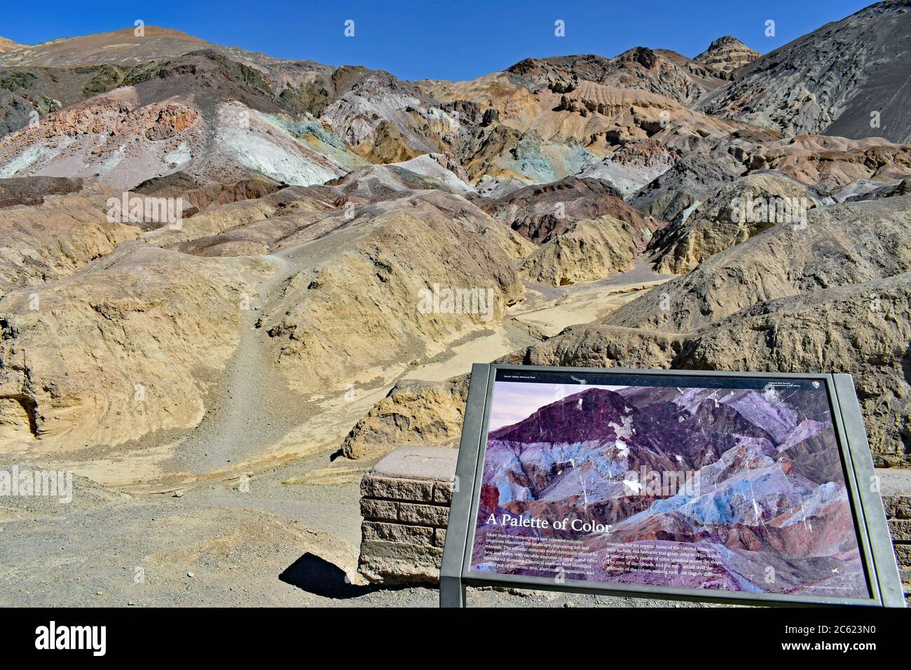 Artisti palette formazioni rocciose multicolore in una giornata limpida con cielo blu. Viene inoltre mostrato il segno interpretativo per i visitatori. Death Valley, California Foto Stock