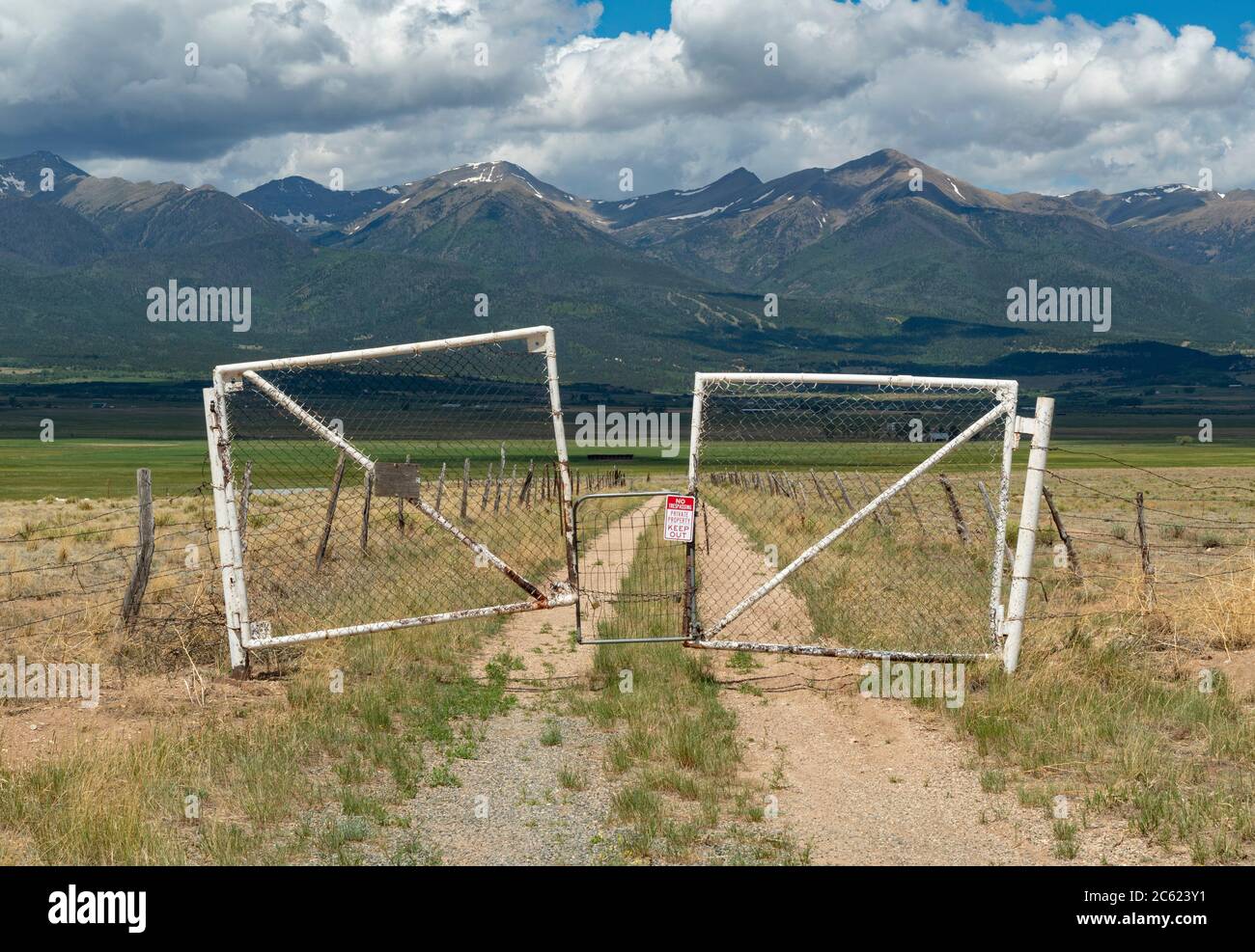 Vecchio cancello in metallo arrugginito con le montagne rocciose, Colorado USA Foto Stock