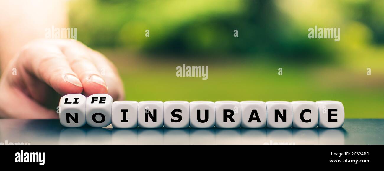 La mano gira i dadi e cambia l'espressione 'nessuna assicurazione' in 'assicurazione sulla vita'. Foto Stock