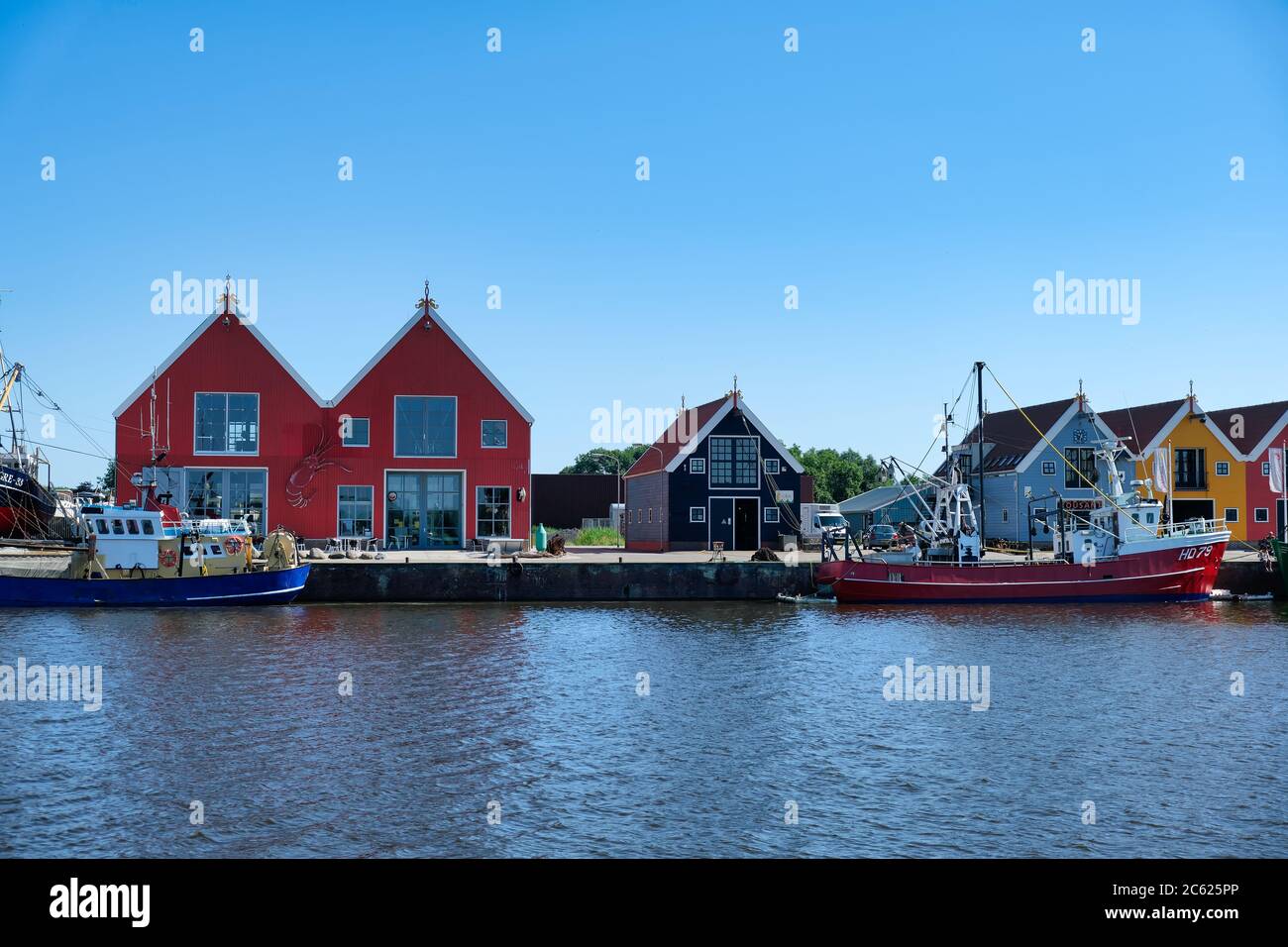 Europa Paesi Bassi Tour attraverso i canali, magazzini colorati nel piccolo porto olandese a Zoutkamp Foto Stock