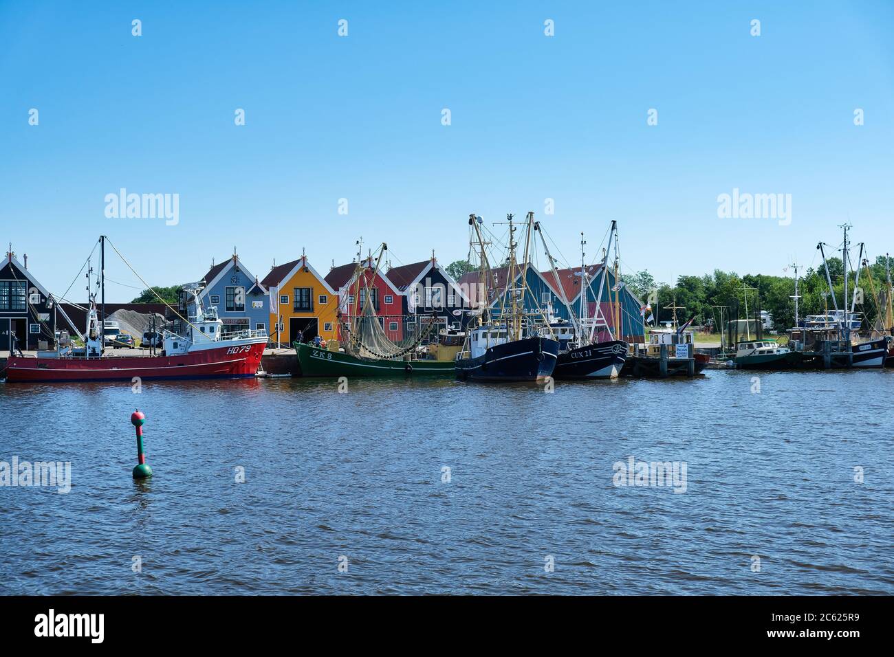 Europa Paesi Bassi Tour attraverso i canali, magazzini colorati nel piccolo porto olandese a Zoutkamp Foto Stock