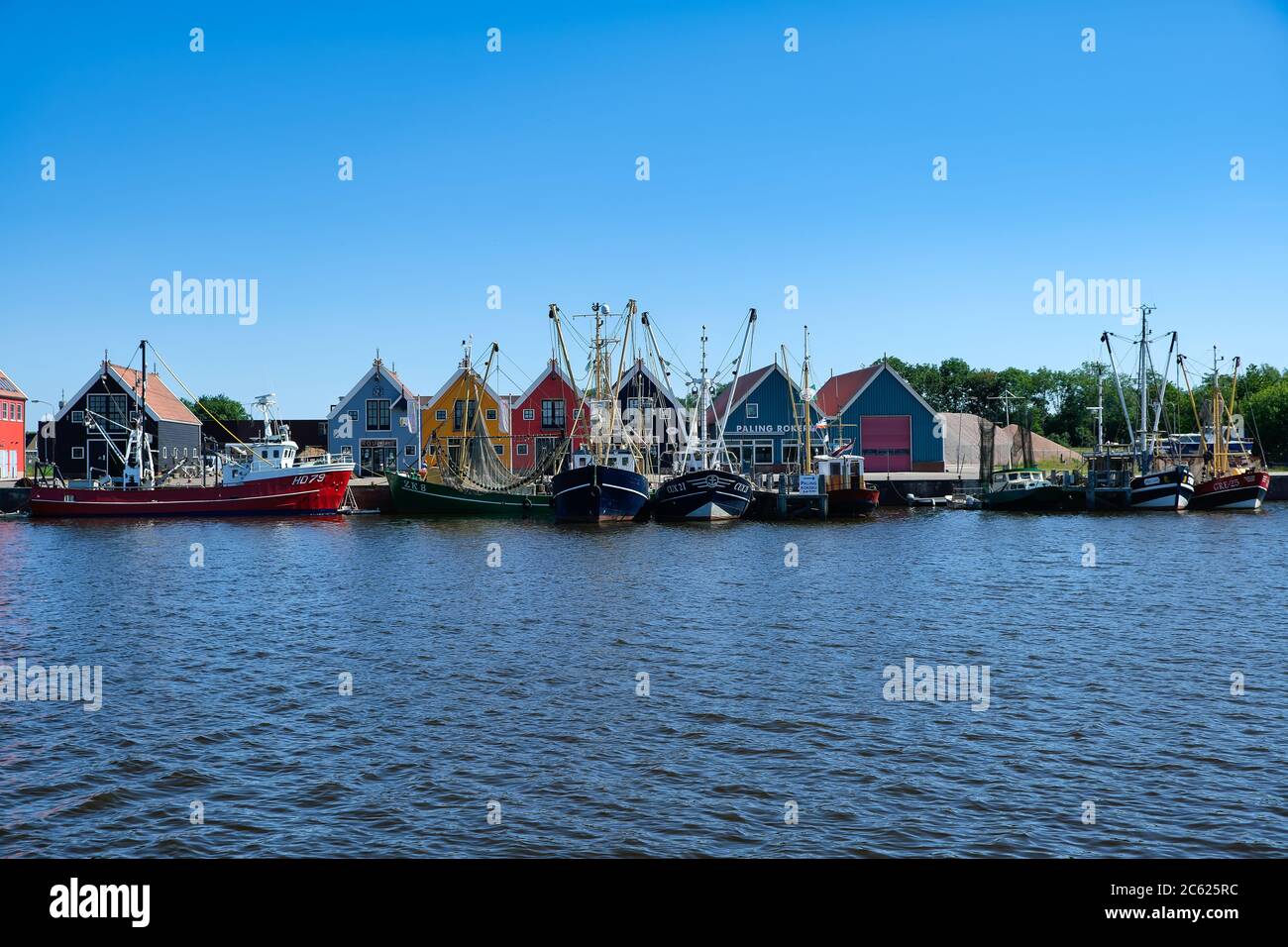 Europa Paesi Bassi Tour attraverso i canali, magazzini colorati nel piccolo porto olandese a Zoutkamp Foto Stock