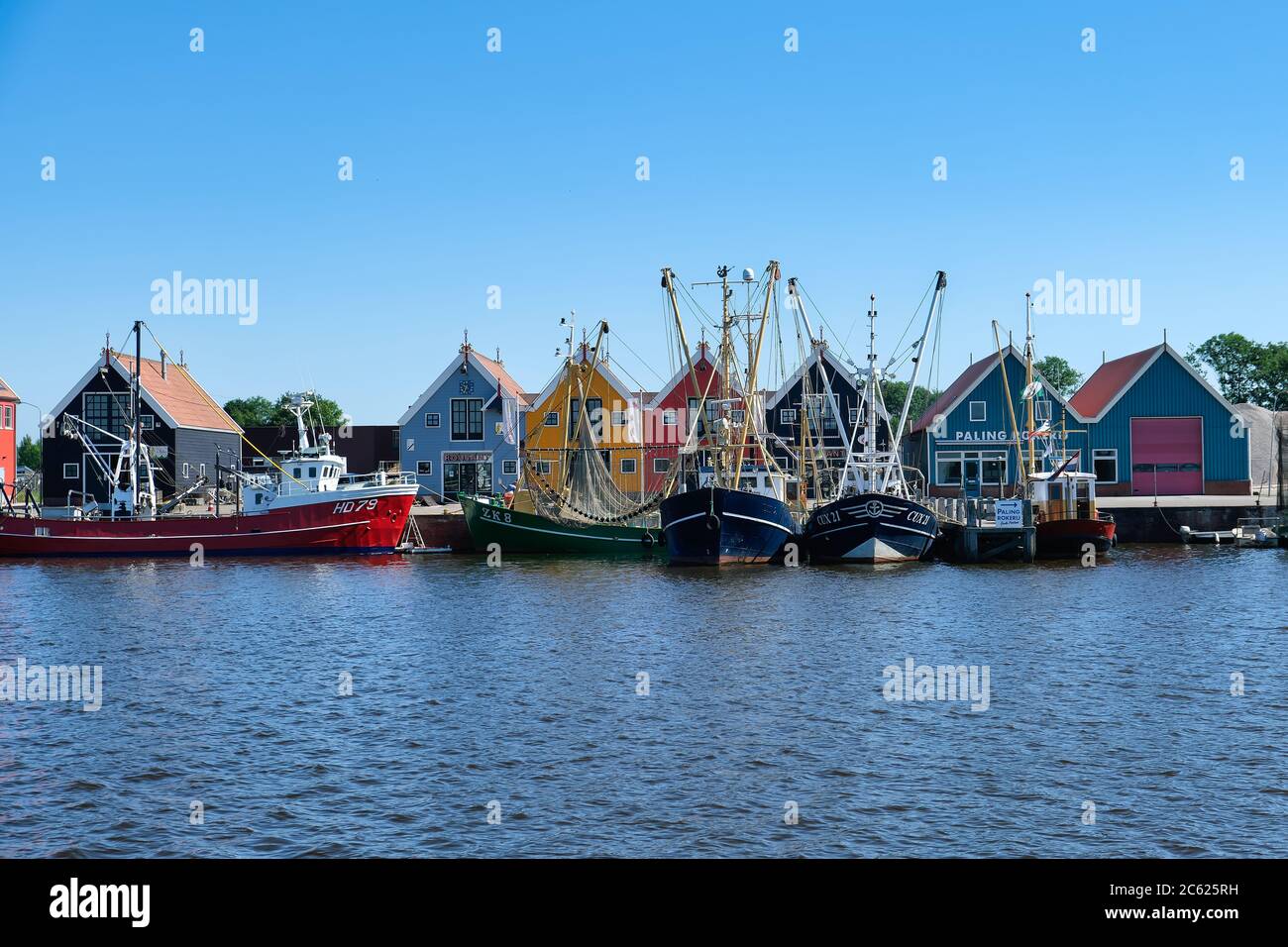 Europa Paesi Bassi Tour attraverso i canali, magazzini colorati nel piccolo porto olandese a Zoutkamp Foto Stock