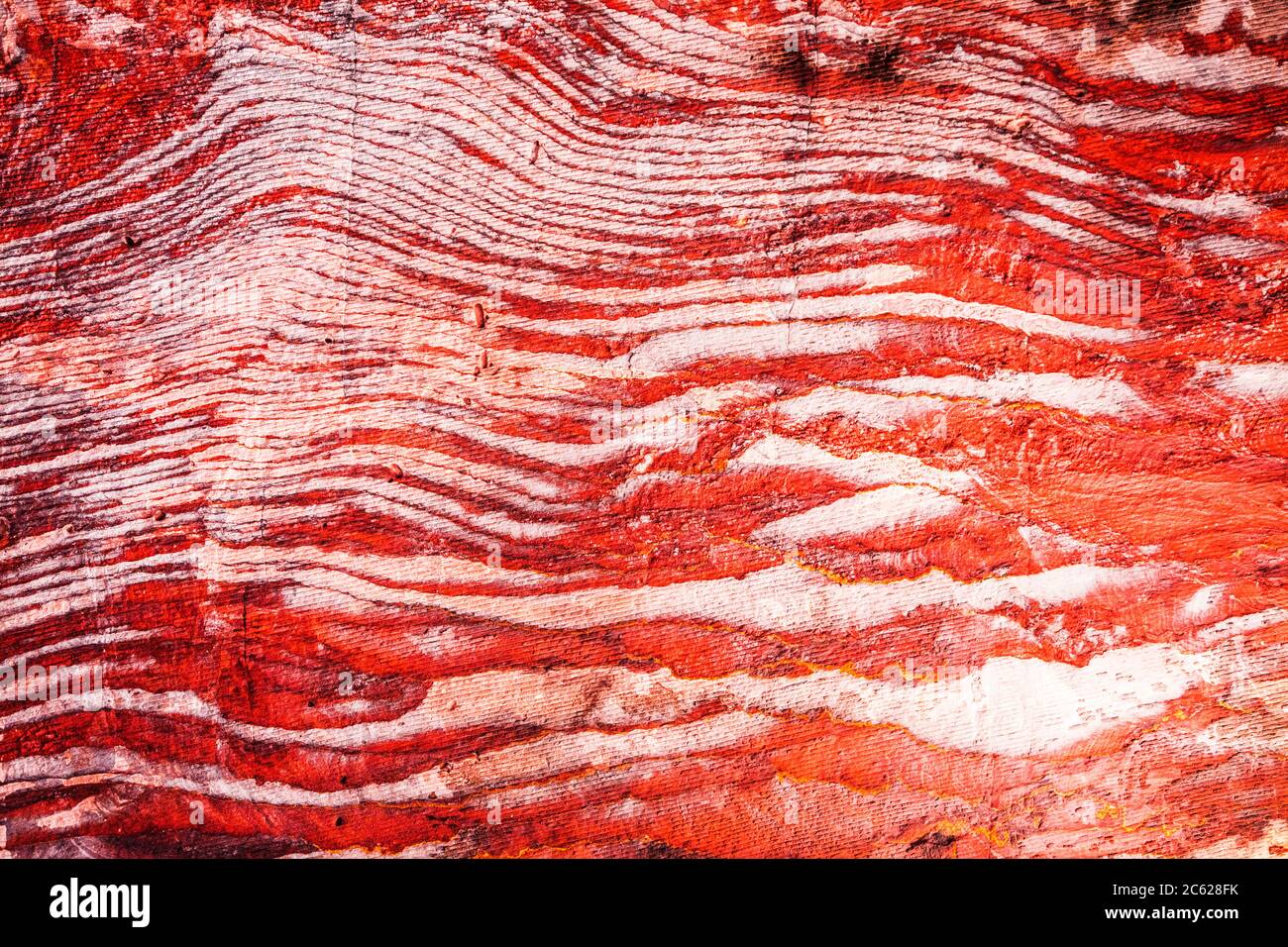 La superficie di pietra arenaria rossa del canyon conosciuta come al Siq all'ingresso della città rosa di Petra in Giordania. Foto Stock