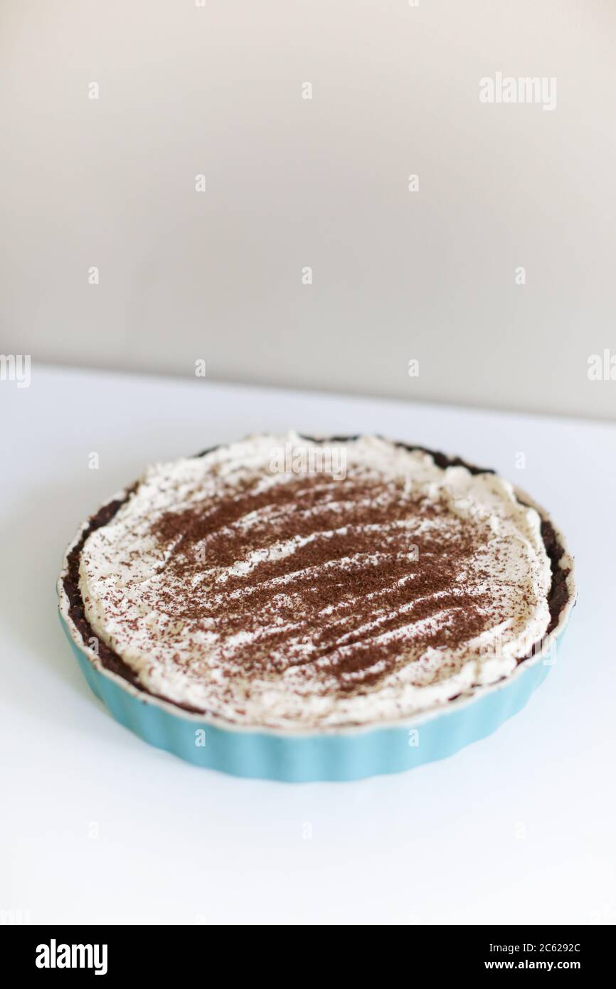 Torta crema al cioccolato Keto su sfondo bianco in piatto blu Foto Stock