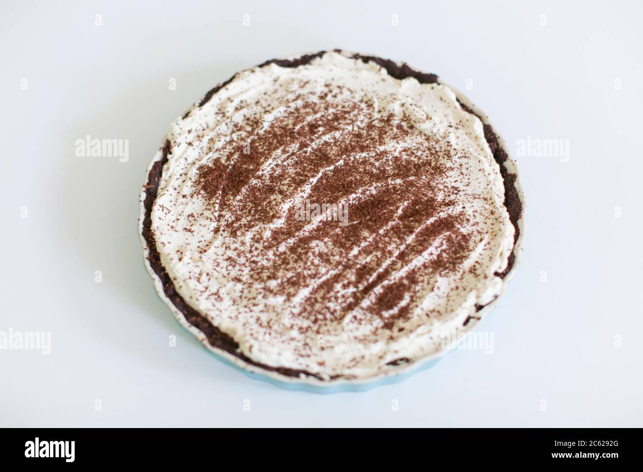 Torta crema al cioccolato Keto su sfondo bianco in piatto blu Foto Stock