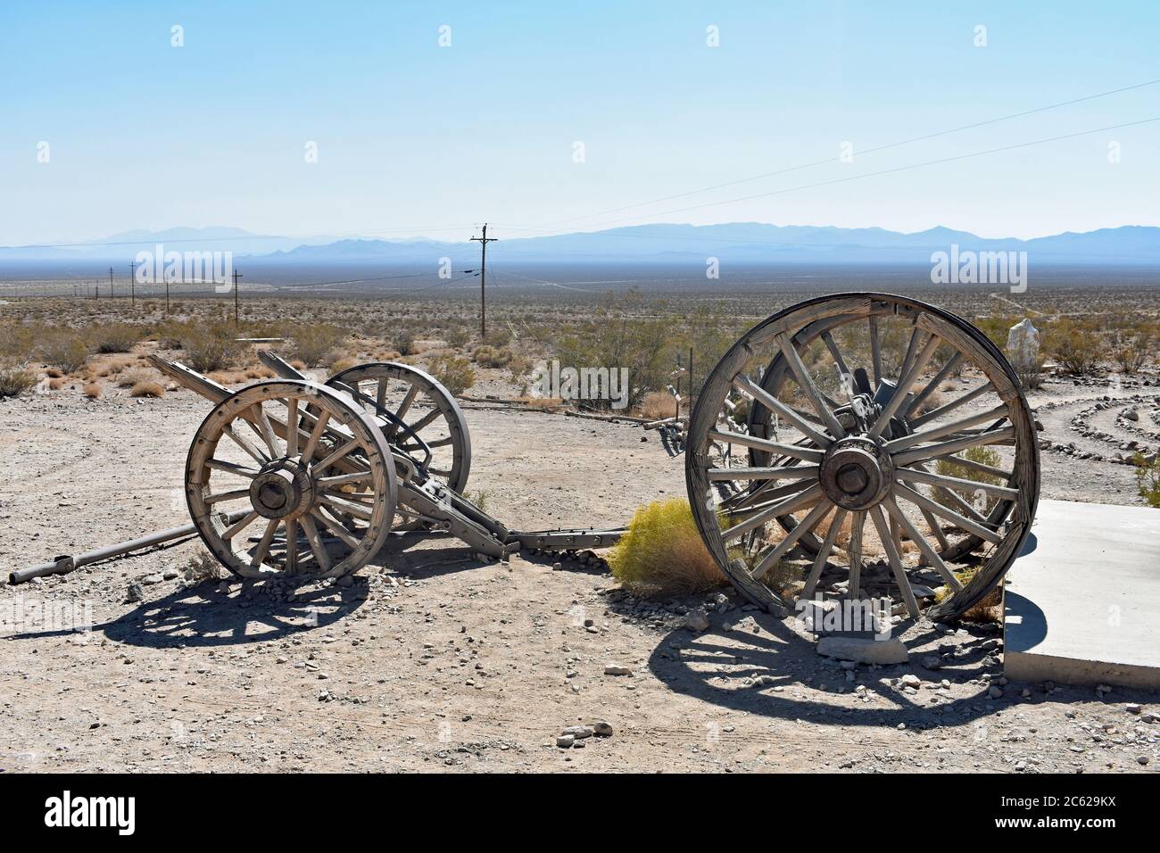 Due serie di ruote del carro abbandonate nel deserto. I piloni scompaiono in lontananza e le montagne all'orizzonte. GOLDWELL museo all'aperto Nevada. Foto Stock