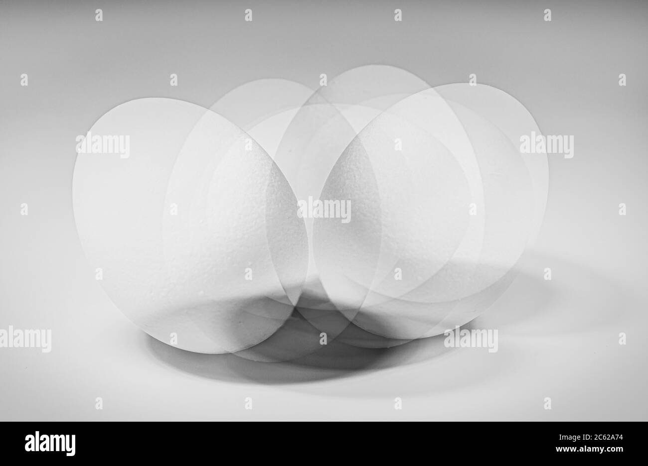 Fotografia a esposizione multipla di un uovo bianco che gira isolato su uno sfondo bianco Foto Stock