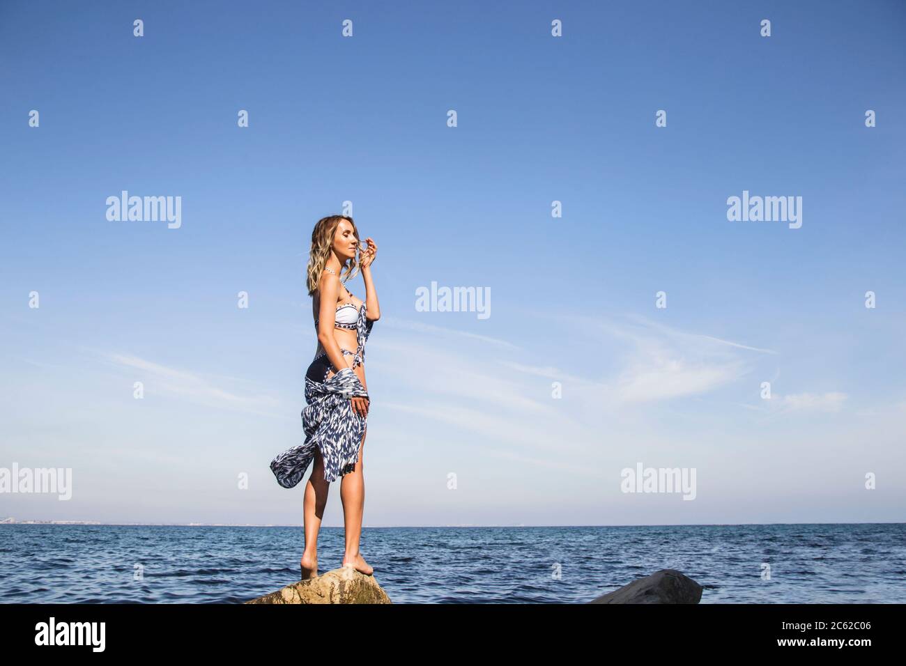 Una bella ragazza sola si erge sulla riva del mare e gode della natura  estiva. Minimalismo Foto stock - Alamy
