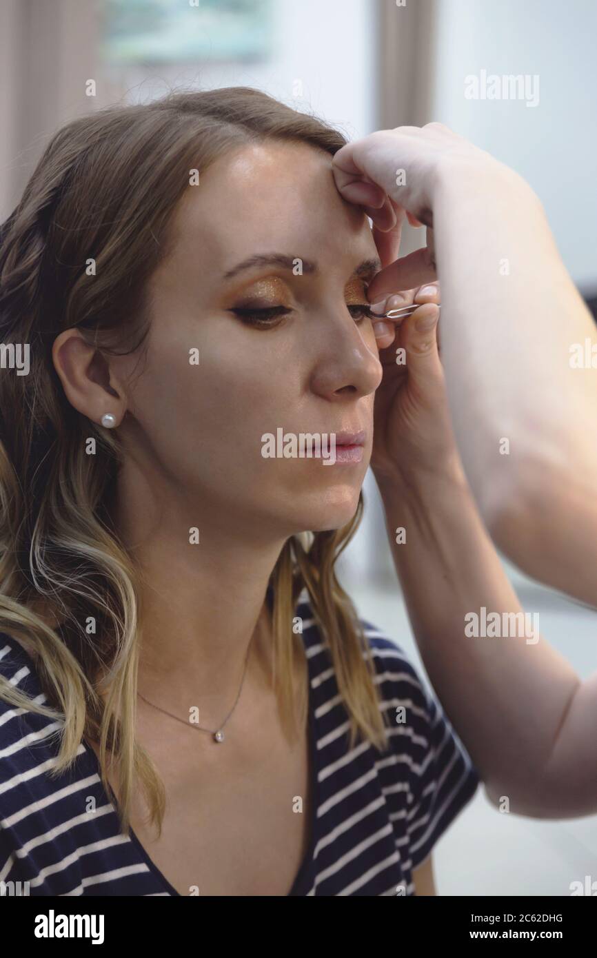Il processo di creazione di un modello di trucco e l'applicazione di ciglia false. Foto Stock