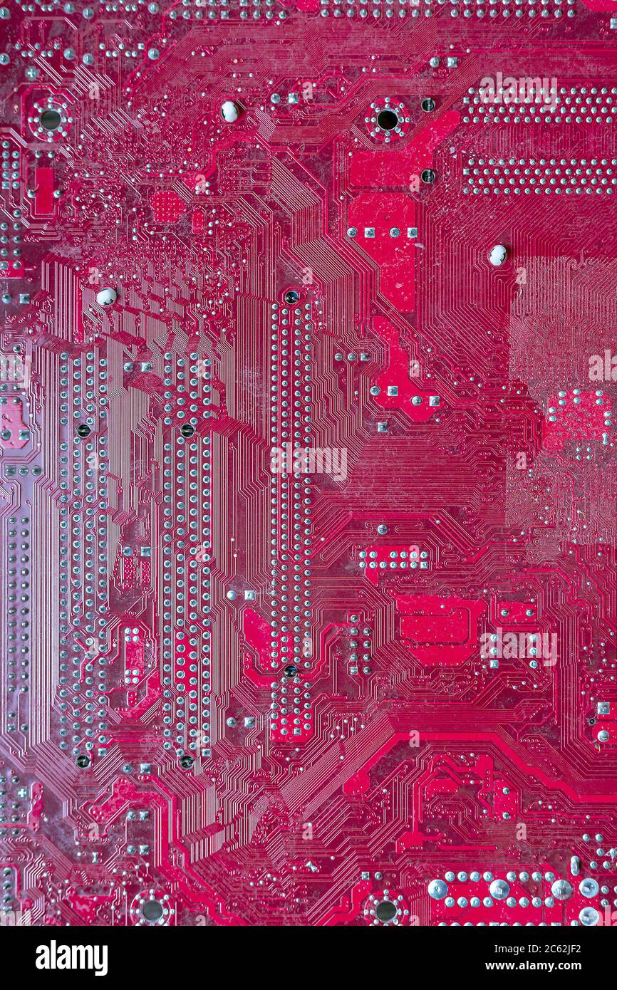 Scheda a circuiti stampati del computer rosa. Componenti hardware. Primo piano, sfondo Foto Stock