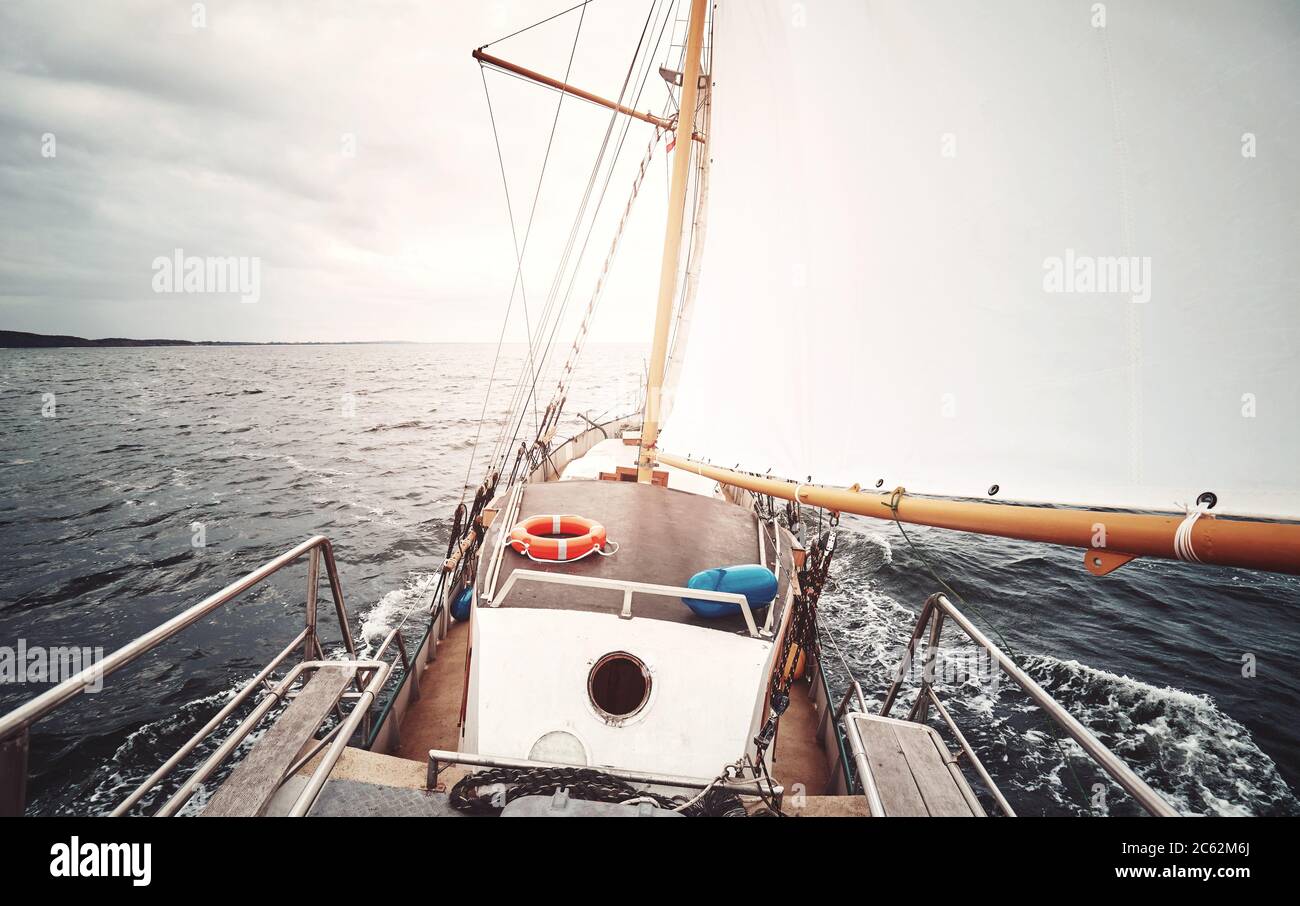 Vela contro il sole, colore tonico immagine di una vecchia goletta. Foto Stock