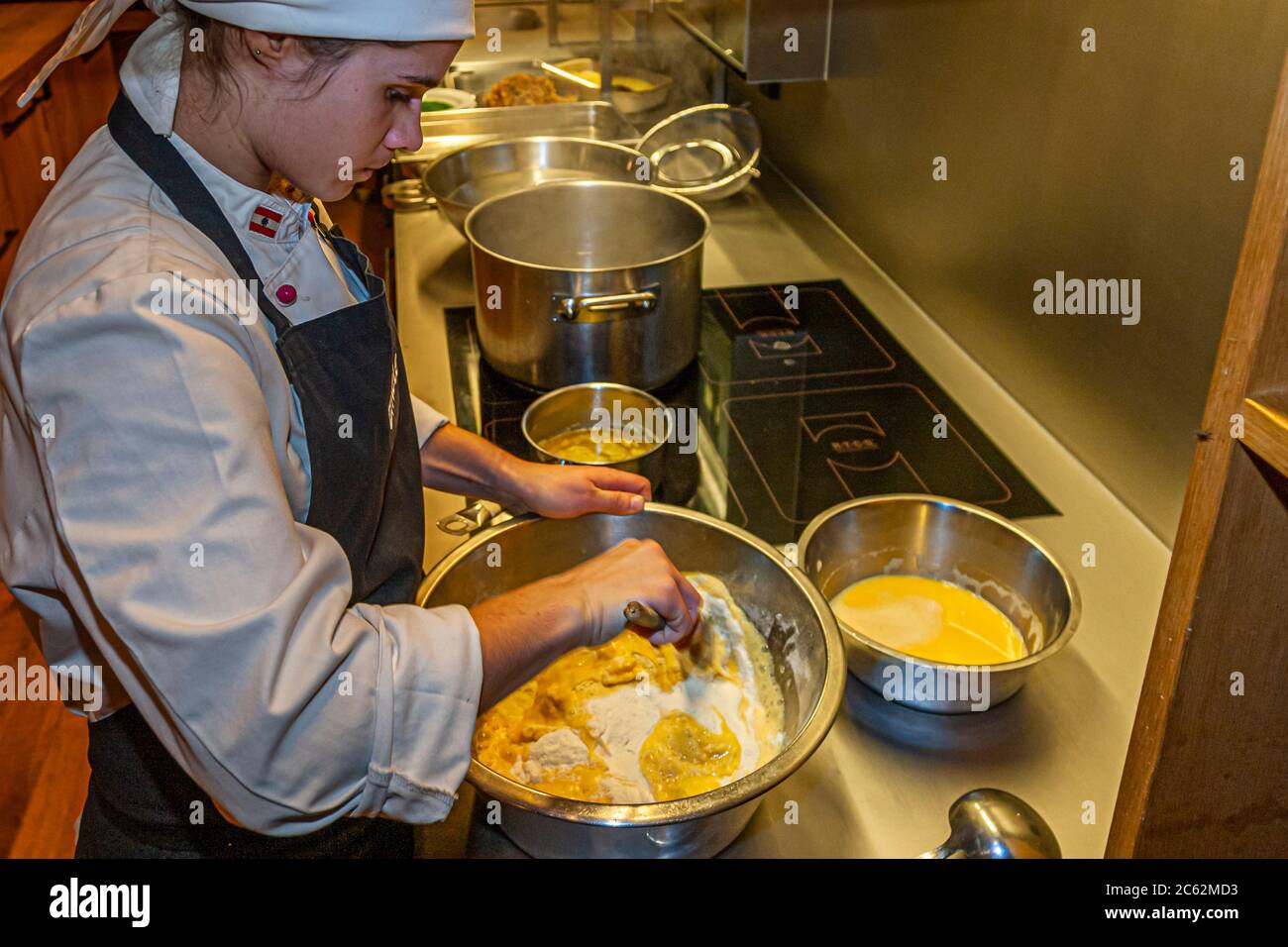 Nella cucina del Romantik Hotel Das Schiff a Hittisau, Vorarlberg, Austria, un cuoco mescola farina, uova e acqua per preparare l'impasto dei Käsknöpfle. Nel Bregenzerwald, i Kässpätzle sono anche conosciuti come Käsknöpfle. Foto Stock