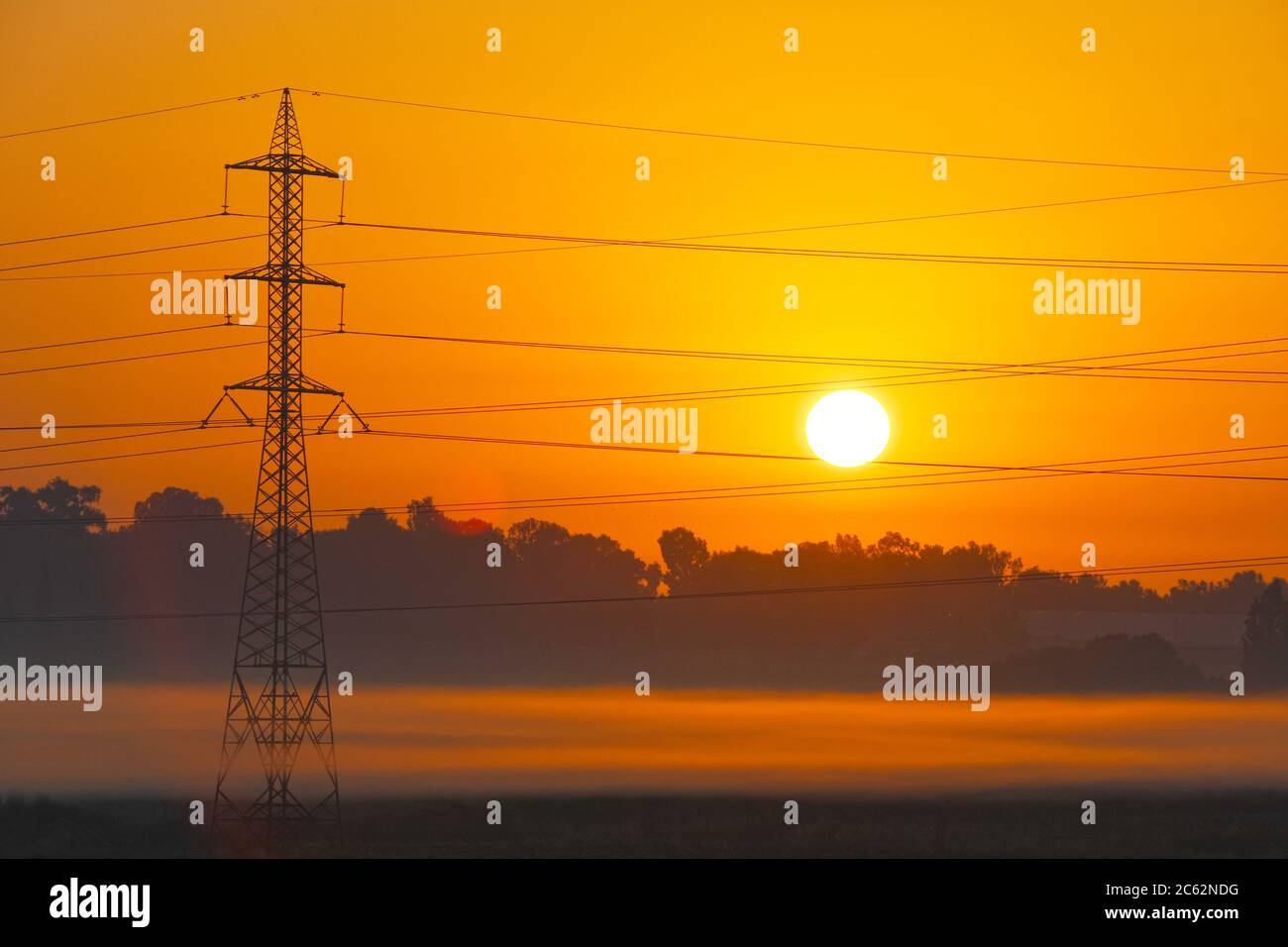 Torre di trasmissione che emerge dalla nebbia all'alba Foto Stock