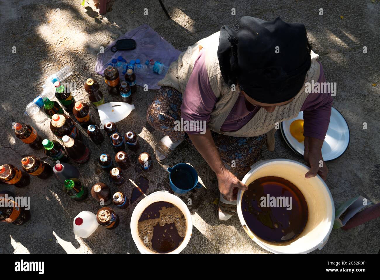 Vista dall'alto della donna turca produce pekmez e le imbottiglia riutilizzando bottiglie di plastica. Foto Stock
