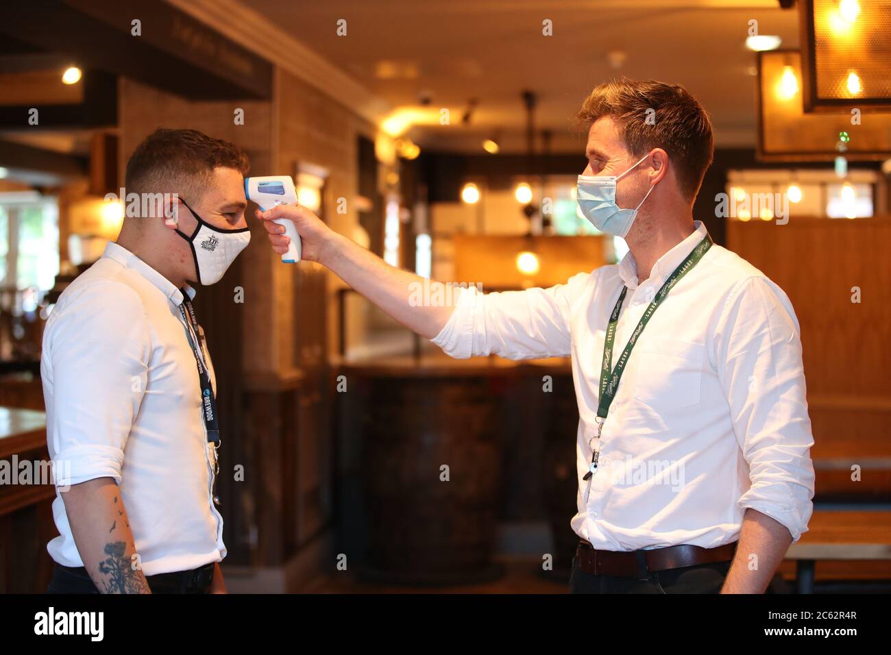 Il barman ben Leslie (a sinistra) fa controllare la temperatura dal manager Steven Winton prima di iniziare il suo turno al pub Scottish Engineer di Edimburgo, Mentre i giardini di birra e le aree di ristoro all'aperto riaprono al pubblico per la prima volta mentre la Scozia continua con la graduale eliminazione delle restrizioni per uscire dalla zona di chiusura. Foto Stock