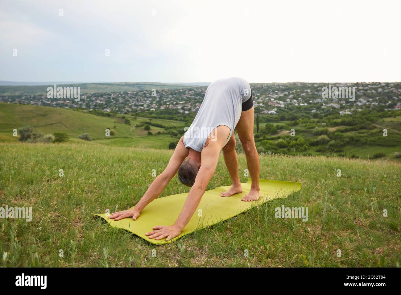 Yoga in natura. Yoga maschile che in estate pratica la meditazione yoga sul campo sulla natura. Foto Stock