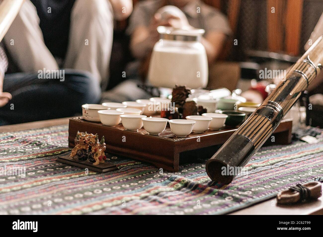 festa del tè in stile boho, hippie. tazze da tè su un tavolino di legno speciale. Preparazione del tè masala. Un didgeridoo. Il tè viene preparato sull'abete Foto Stock festa del tè in stile boho, hippie. tazze da tè su un tavolino di legno speciale. Preparazione del tè masala. Un didgeridoo. Il tè viene preparato sull'abete Foto Stock