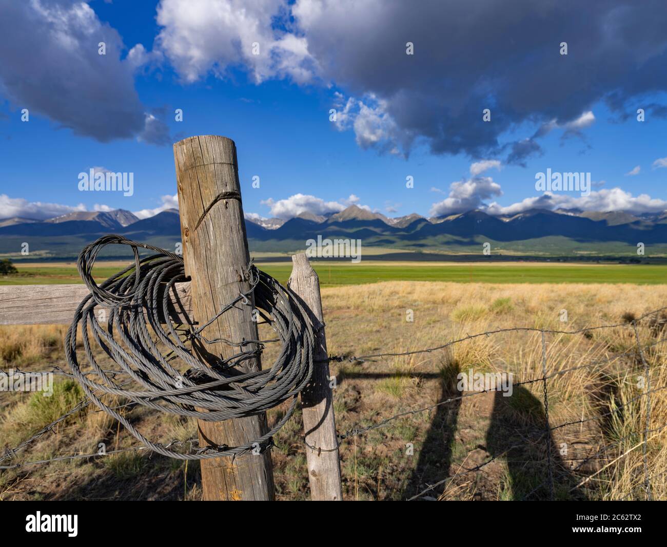 Vecchio palo recinzione indossato con montagne rocciose sullo sfondo, Colorado, USA Foto Stock