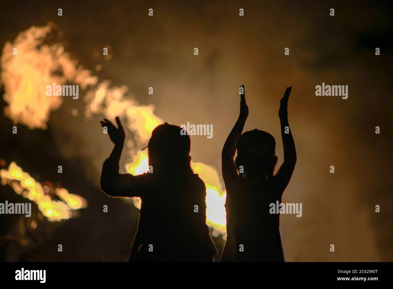 sagome dei bambini sullo sfondo del fuoco. Bambini che guardano al fuoco Foto Stock