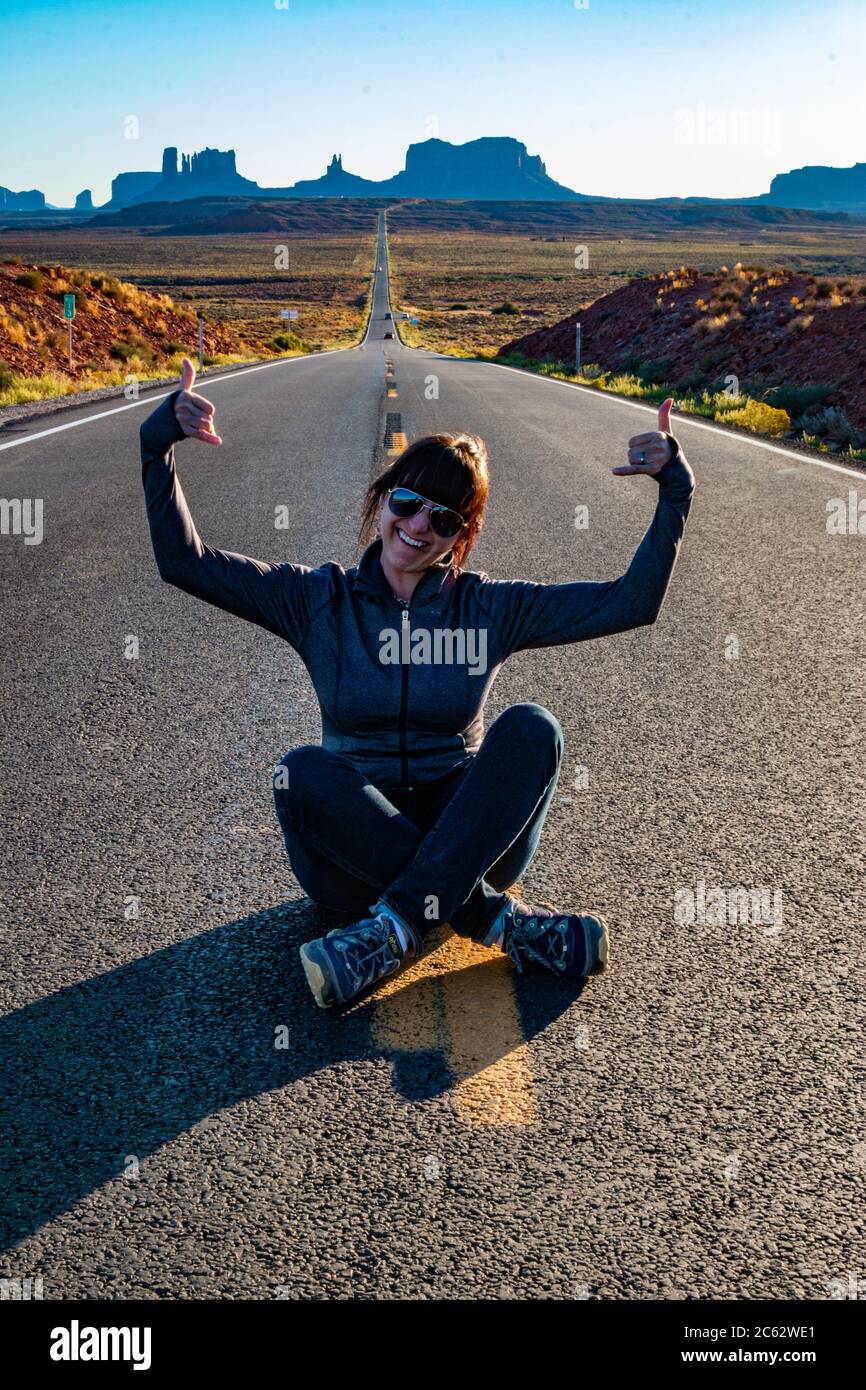 Un turista si pone al centro della strada che porta alla Monument Valley e reso famoso dal film Forest Gump. Foto Stock