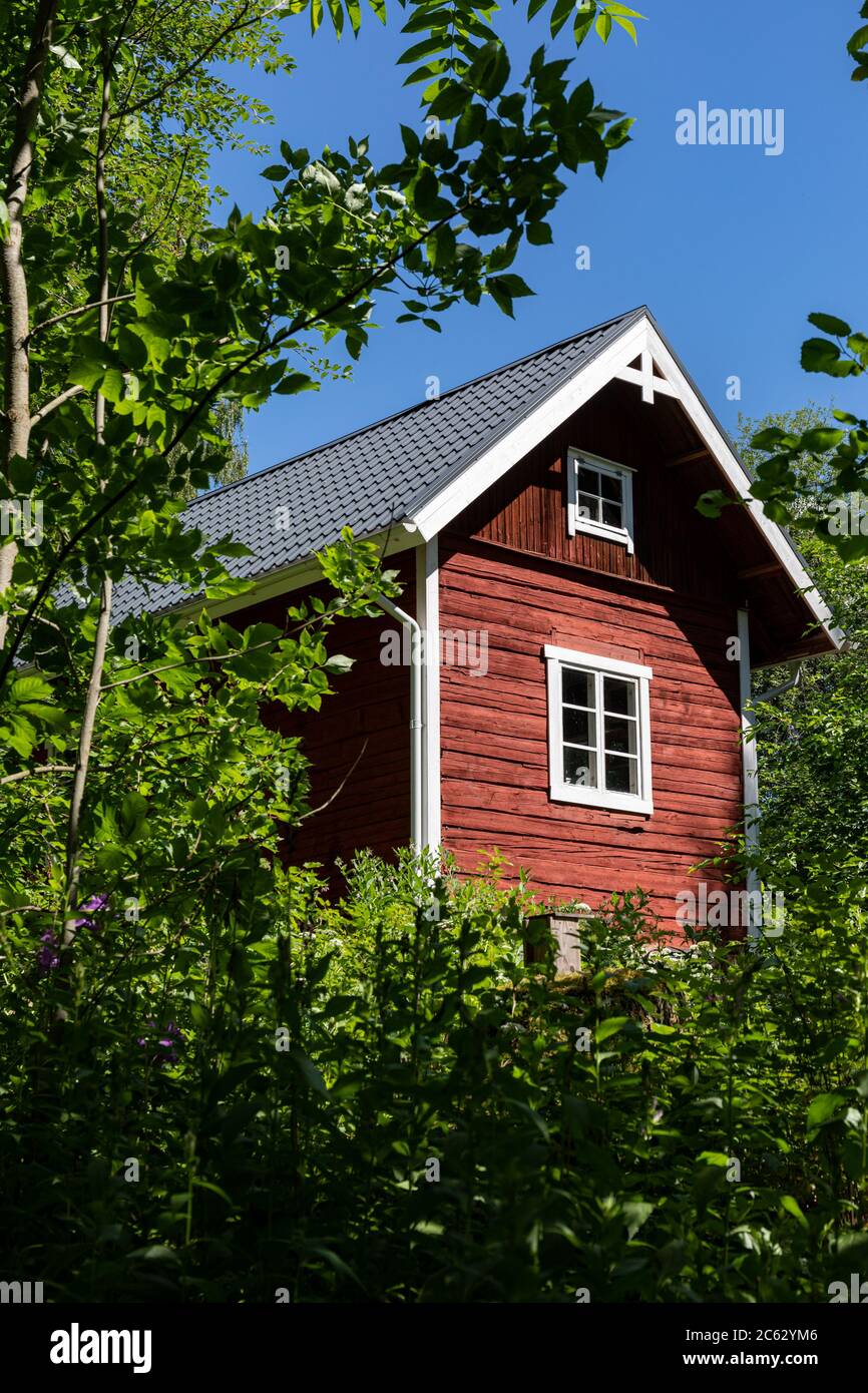 Piccola casa di tronchi di ocra rossa a Hörtsänä Arboretum in Orivesi, Finlandia Foto Stock