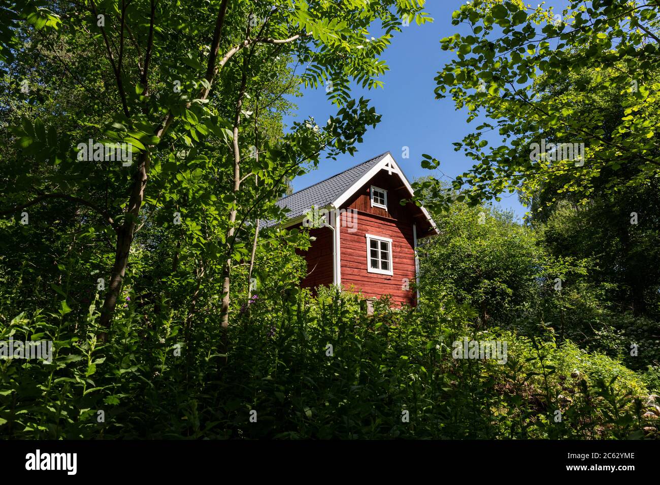 Piccola casa di tronchi di ocra rossa a Hörtsänä Arboretum in Orivesi, Finlandia Foto Stock
