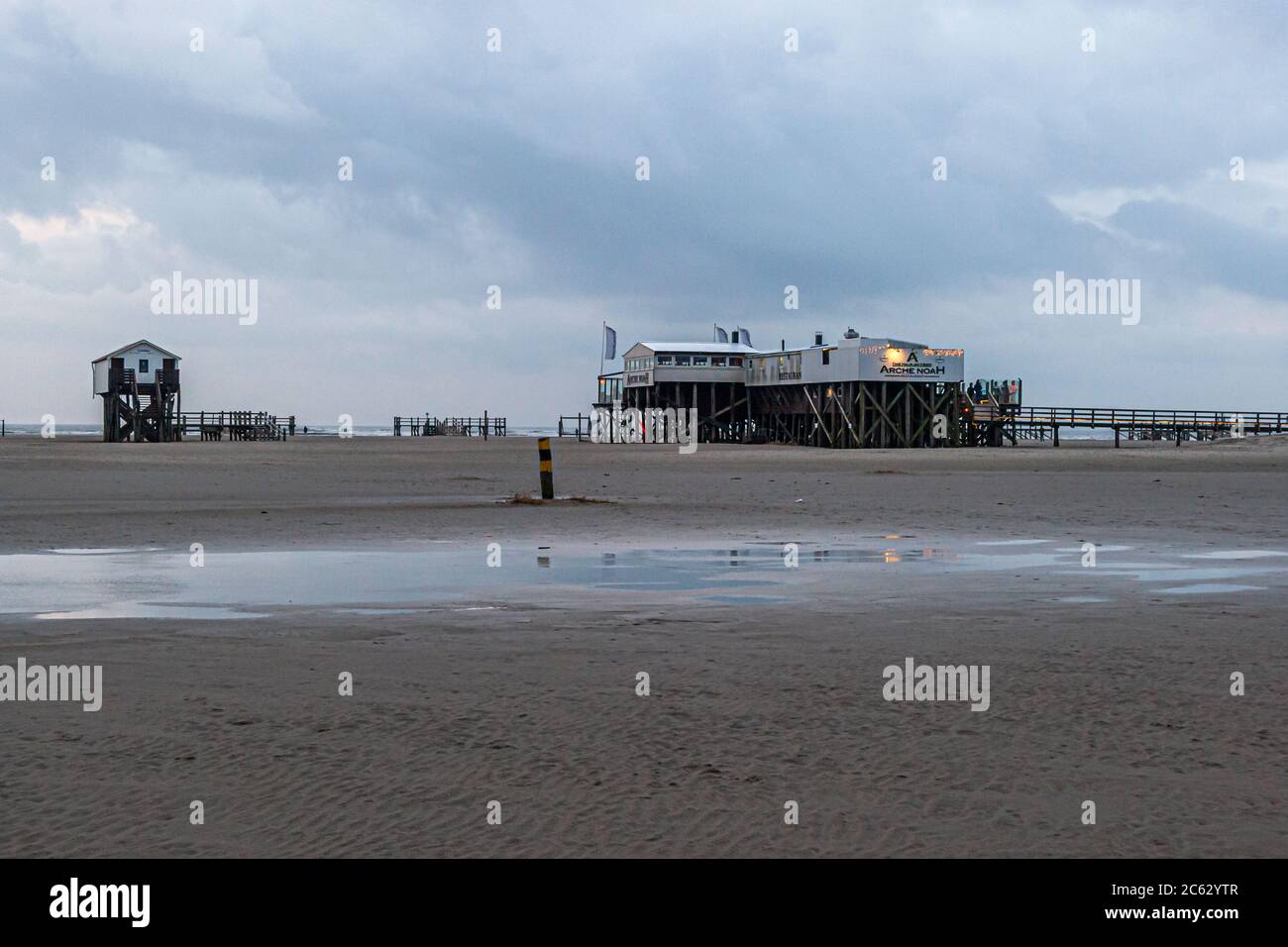 Spiaggia di Sankt Peter-Ording, Germania. Le palafitte si innalzano fino a sette metri sopra la spiaggia. Da oltre 100 anni, le costruzioni in legno di larice hanno modellato l'immagine della spiaggia di San Pietro-Ording. Dimora del lago, casa molo sulla spiaggia di San Pietro Ording in Germania Foto Stock