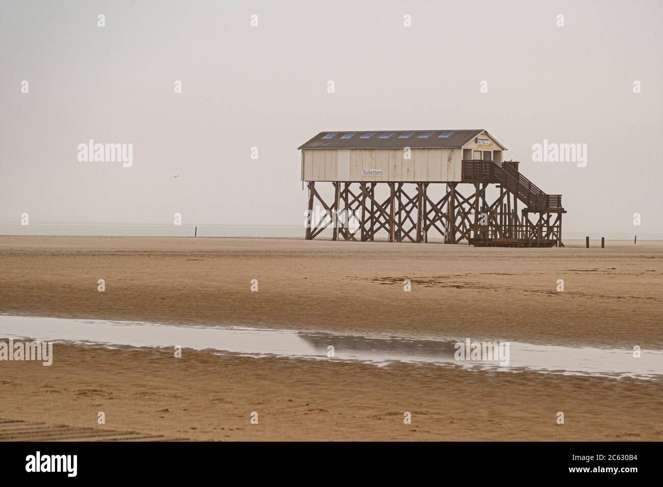 Le palafitte si innalzano fino a sette metri sopra la spiaggia. Da oltre 100 anni, le costruzioni in legno di larice hanno modellato l'immagine della spiaggia di San Pietro-Ording. Dimora del lago, casa molo sulla spiaggia di San Pietro Ording in Germania Foto Stock