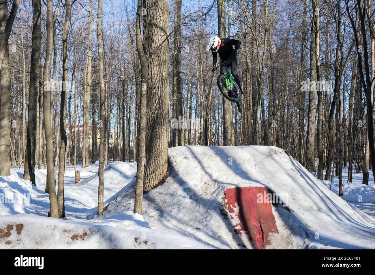 il pilota mtb fa trick sul salto di sporcizia in inverno. Ciclista che fa acrobazie di trampolino Foto Stock
