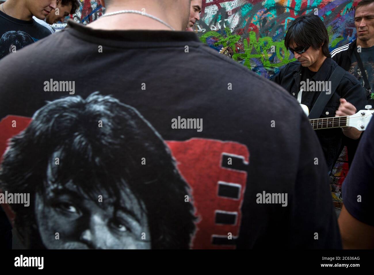 Mosca, Russia. 15 agosto 2015 UN fan di Viktor Tsoi canta una canzone con una chitarra sullo sfondo del Muro di Tsoi in via Arbat a Mosca, il 25° anniversario della morte del cantante, la Russia. Il Muro di Tsoi è un muro coperto di graffiti a Mosca, dedicato al musicista Viktor Tsoi e alla sua band Kino Foto Stock