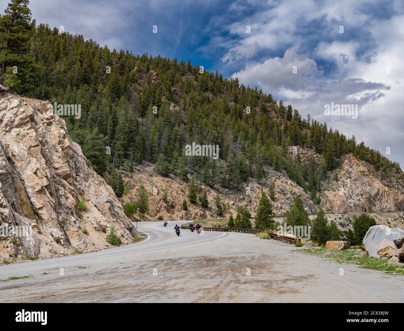 Gruppo di motociclette su autostrada curva attraverso montagne rocciose, Colorado, Stati Uniti Foto Stock