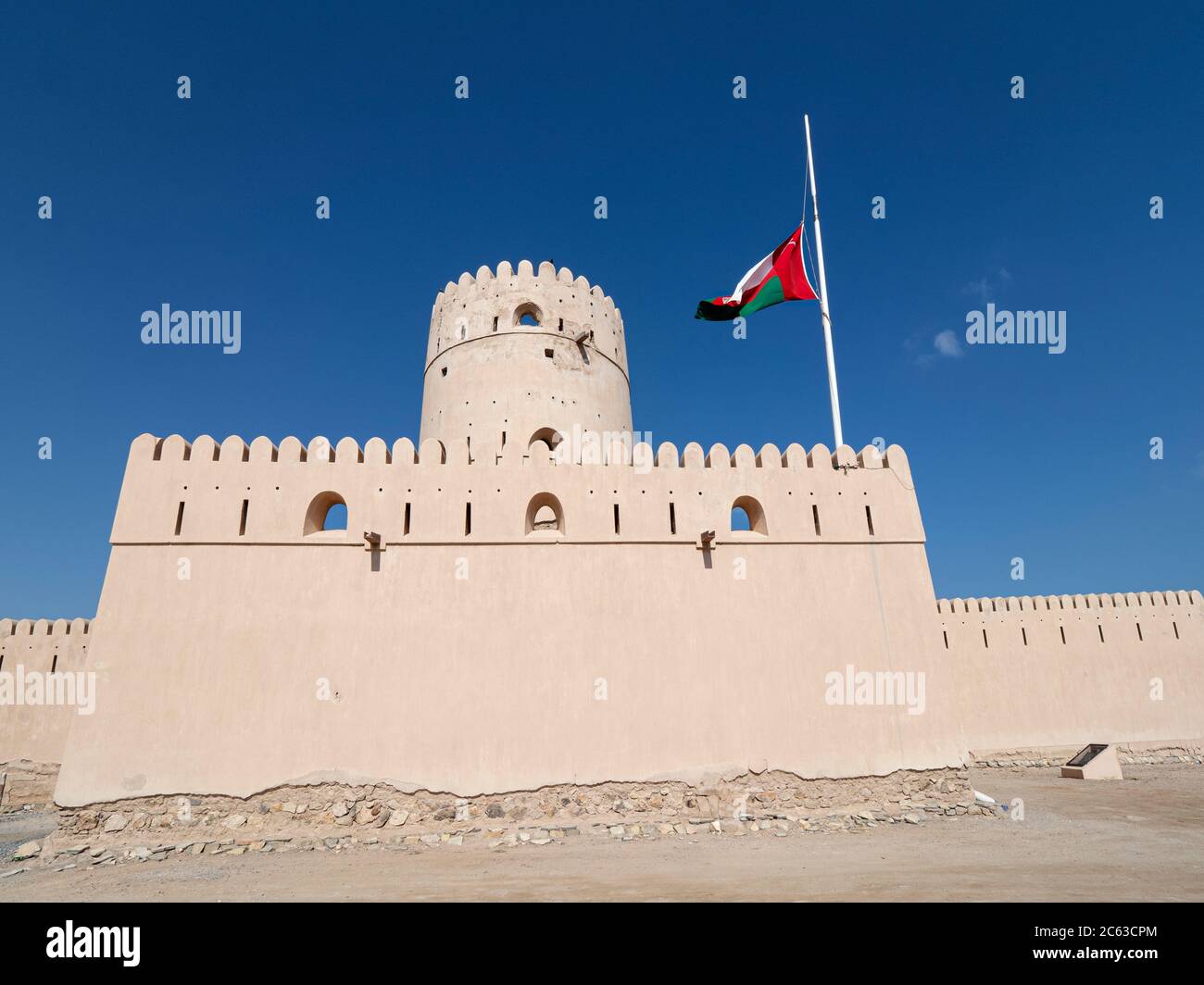 La bandiera di Omani a metà albero per indicare la morte del sultano Qaboos al Castello di Ras al Had, Sultanato di Oman. Foto Stock