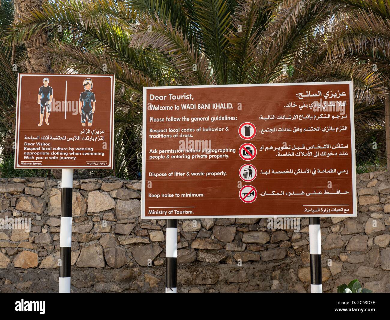 Cartelli turistici affissi vicino alle piscine formate da acque alluvionali a Wadi Bani Khalid, Sultanato dell'Oman. Foto Stock