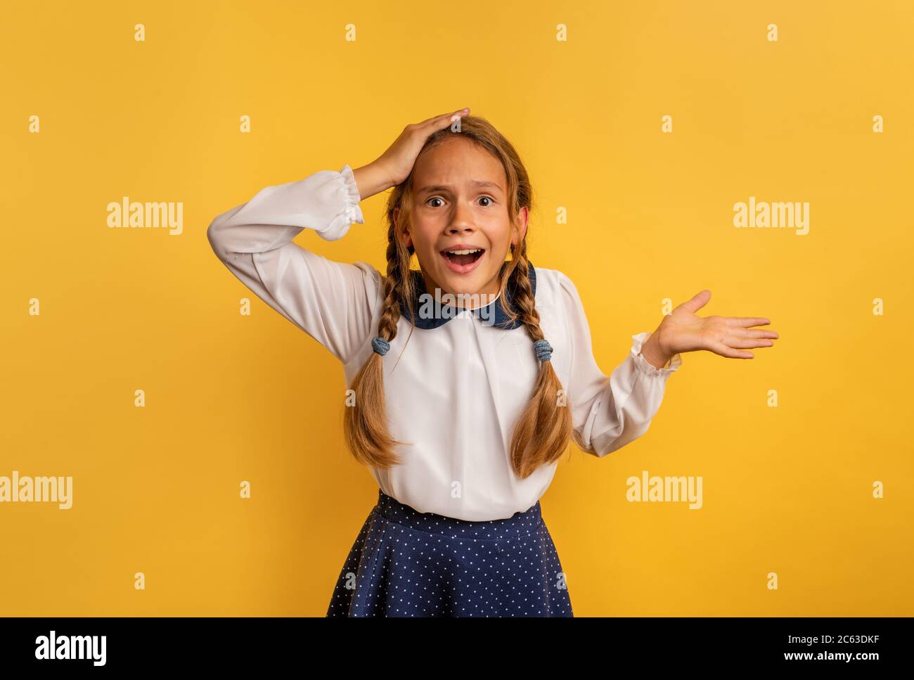 Il giovane studente è stupito di qualcosa . Sfondo giallo studio Foto Stock