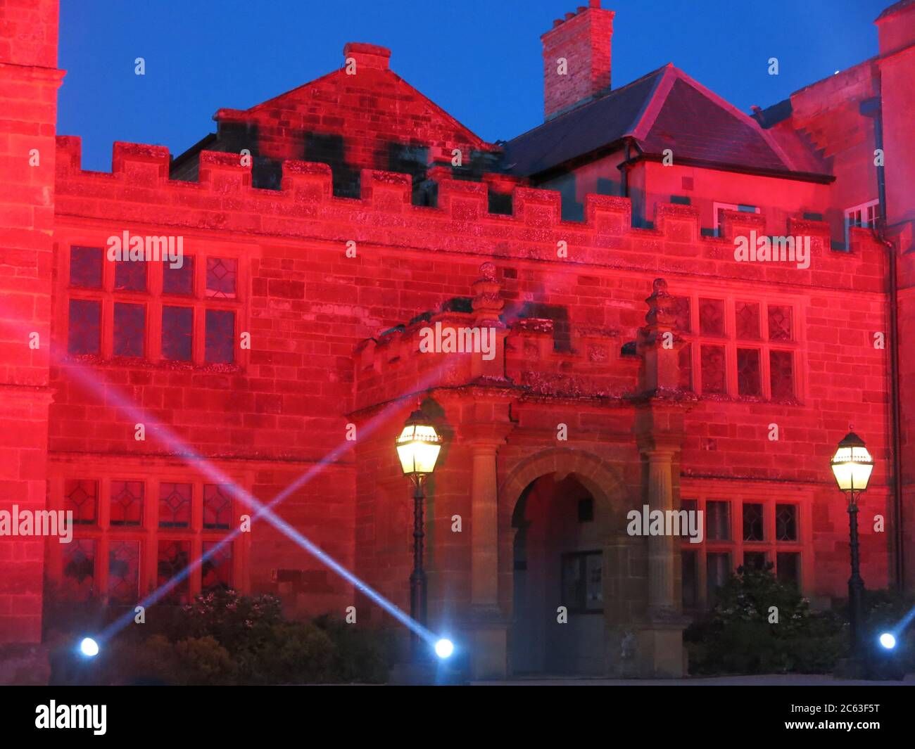 L'ingresso e la facciata anteriore dell'Abbazia di Delapre illuminate di notte in luce rossa e con faretti per l'iniziativa Light IT in Red; 6 luglio 2020 Foto Stock