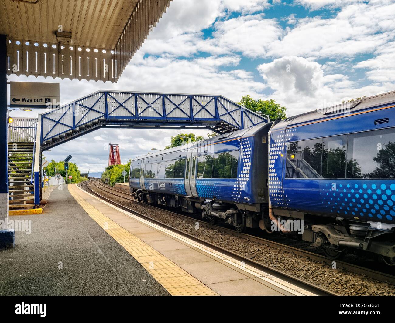 Treno ScotRail alla stazione North Queensferry di Fife, Scozia, con sullo sfondo l'iconico Forth Bridge, un sito patrimonio dell'umanità dell'UNESCO. Foto Stock