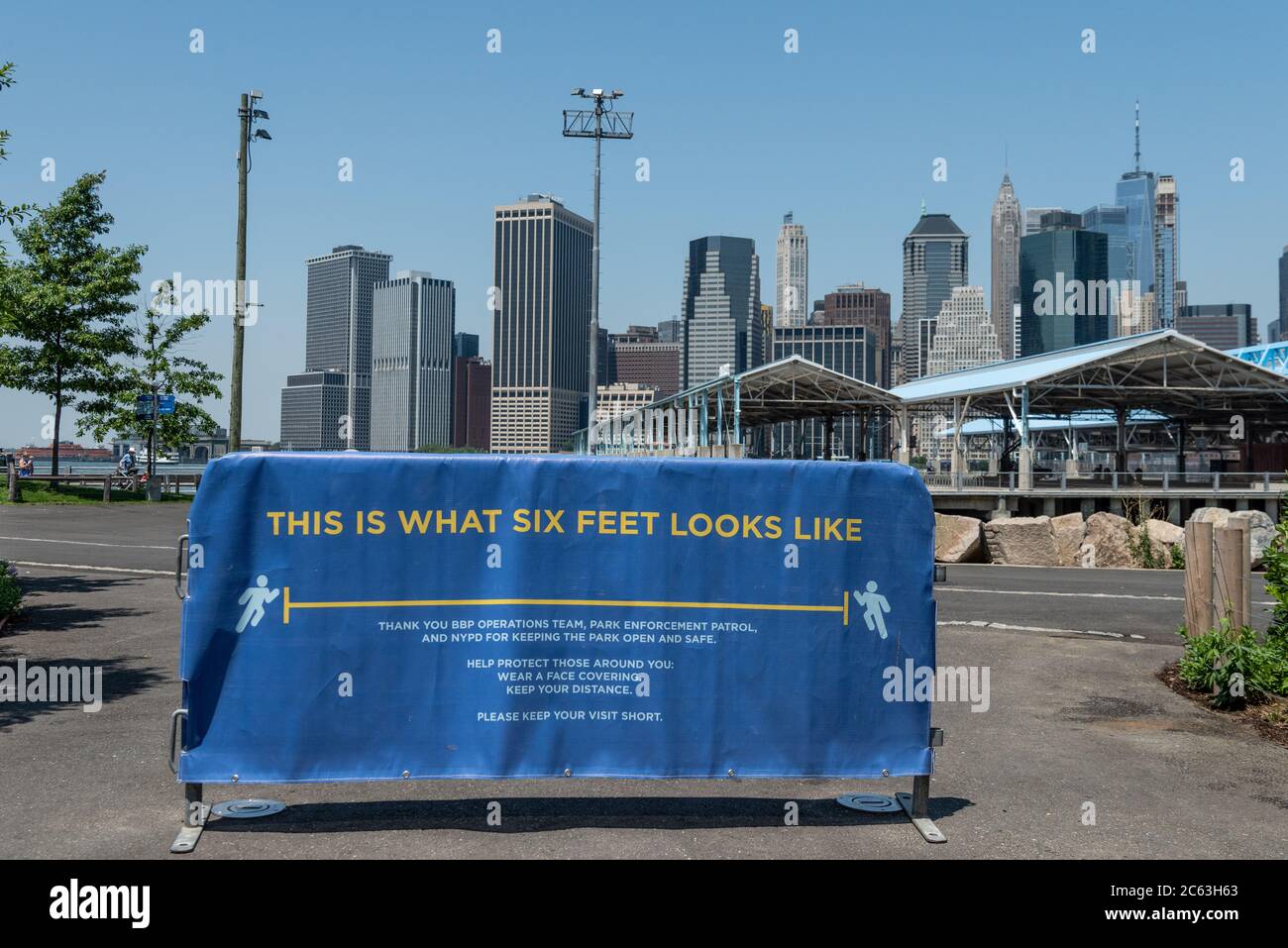 Un banner all'esterno del Brooklyn Bridge Park ricorda ai goer del parco di mantenere una distanza di circa sei metri, quando New York City entra nella fase 3 del Coronavirus, che si apre il 6 luglio 2020 a New York City. (Foto di Gabriele Holtermann/Sipa USA) Credit: Sipa USA/Alamy Live News Foto Stock