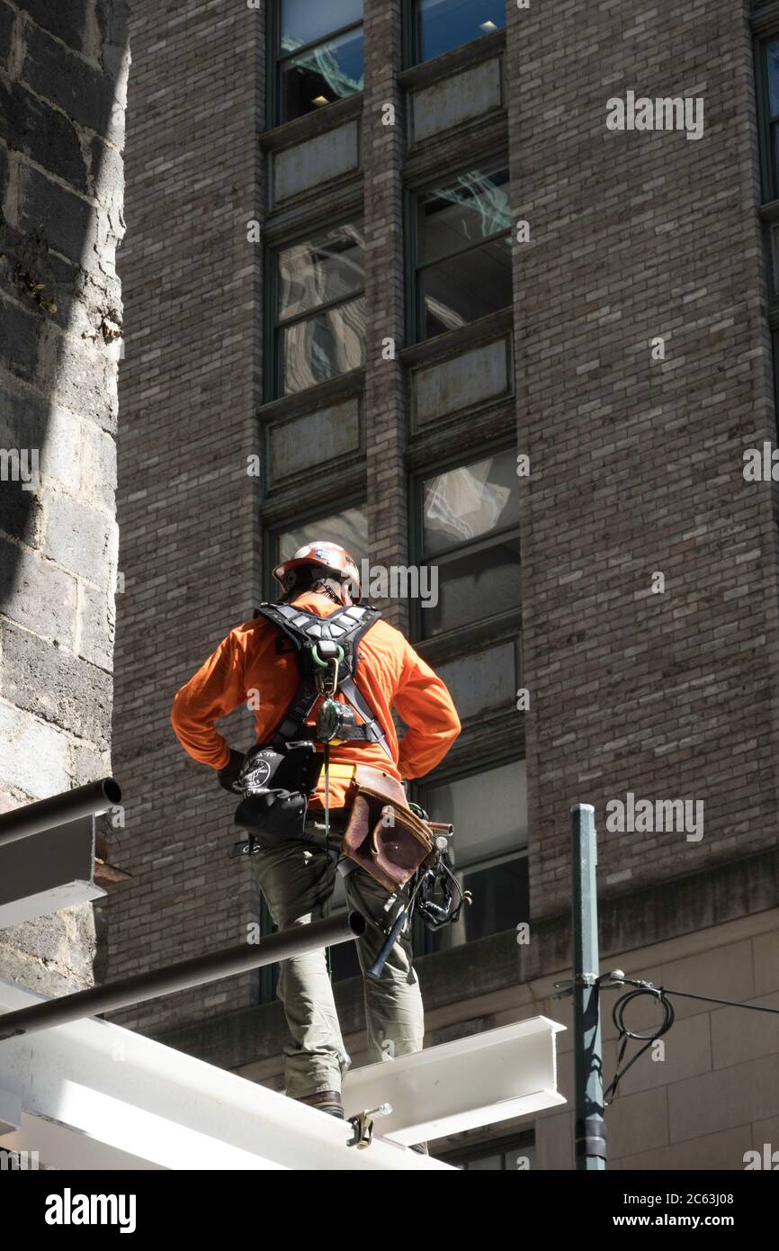 Lavoratore di costruzione in piedi su e i-beam in un cantiere di grattacieli a New York City, Stati Uniti Foto Stock