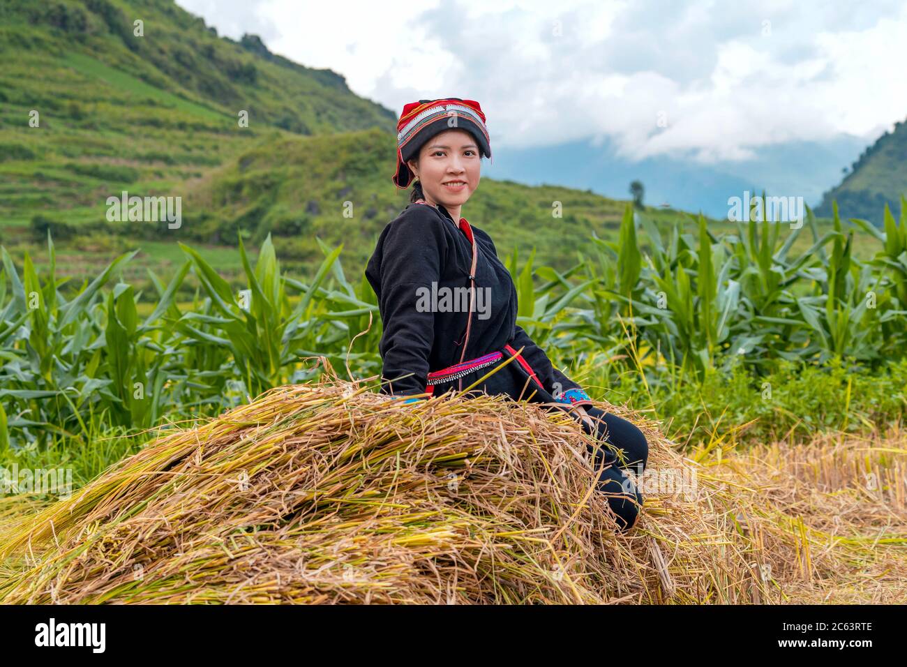 Giovane donna Yao seduta su haystack Foto Stock
