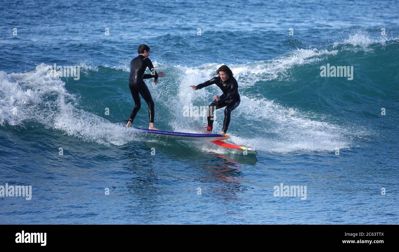 Etichetta di brutto surf - due giovani surfisti si scontrano dopo aver preso la stessa onda Foto Stock