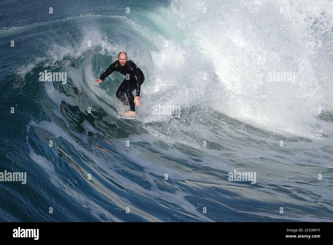 Il surfista maschile più anziano che cavalca un'onda grande e curling Foto Stock