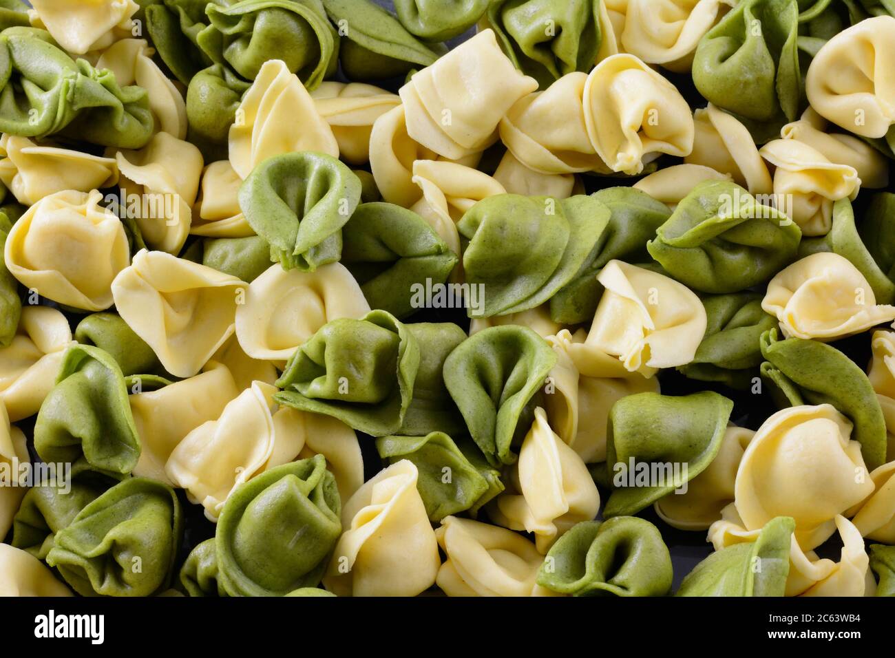 Primo piano di spinaci e tortellini di formaggio di grano con fondo di pasta alimentare Foto Stock