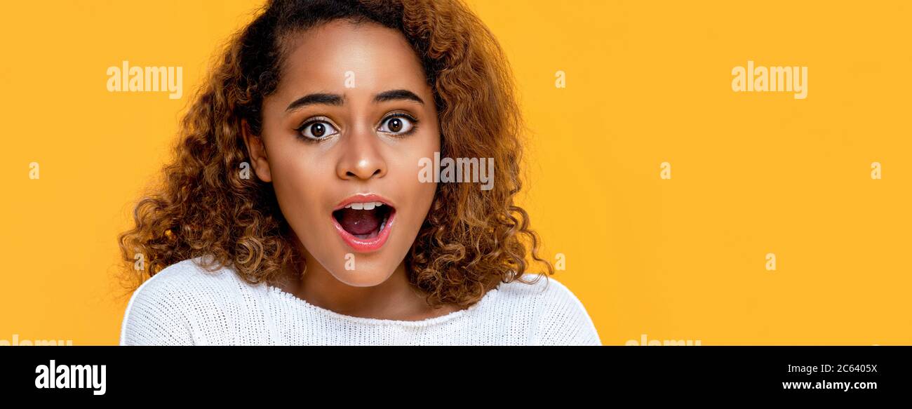 Sorpresa mista africana donna che gasping isolato su sfondo giallo banner con copia spazio Foto Stock