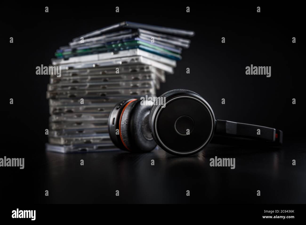 Cuffie Hi-Fi su una pila di CD su sfondo nero con spazio per la copia. Foto Stock