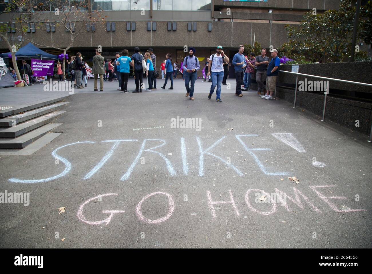 "Sciopero! Go home" è scritto in gesso sul terreno, fuori dall'ingresso principale dell'Università della tecnologia di Sydney. Foto Stock