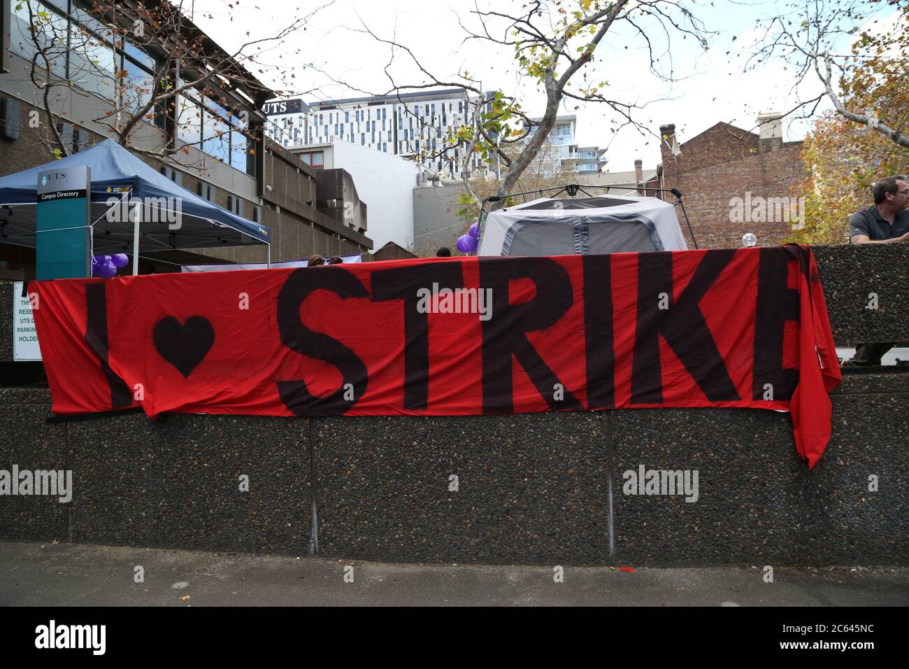 Un banner che dice ‘Io amo lo sciopero’ attaccato a un muro di fronte all’Università della tecnologia, Sydney a Broadway. Foto Stock